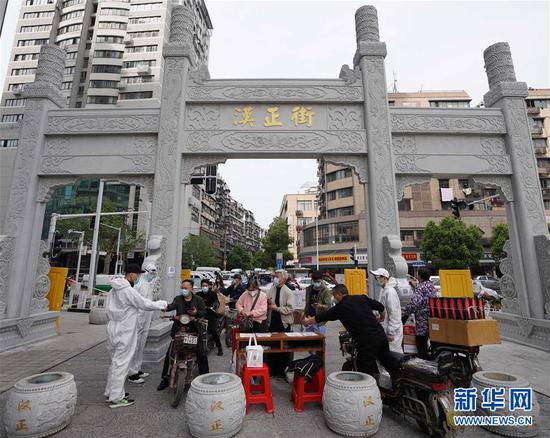  4月16日，進(jìn)出武漢漢正街步行街的人員在掃描健康碼。新華社記者 王毓國 攝